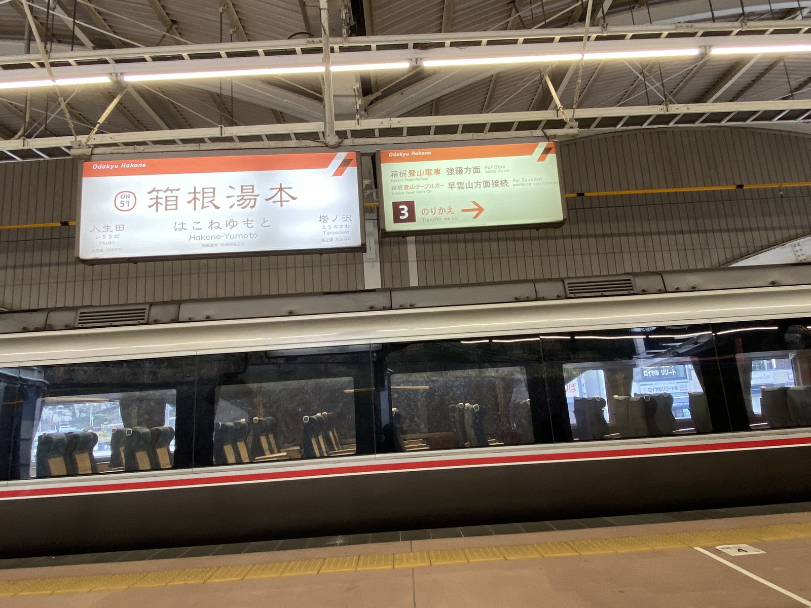 箱根湯本駅の駅名標と停車中の小田急ロマンスカー
