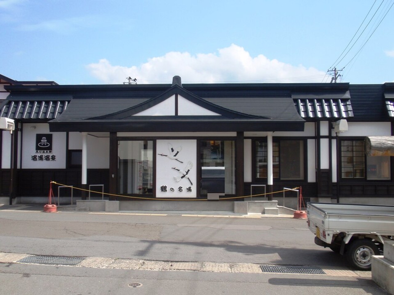共同浴場「鶴の名湯 温湯温泉共同浴場」の外観（鶴の意匠の白壁と黒屋根）