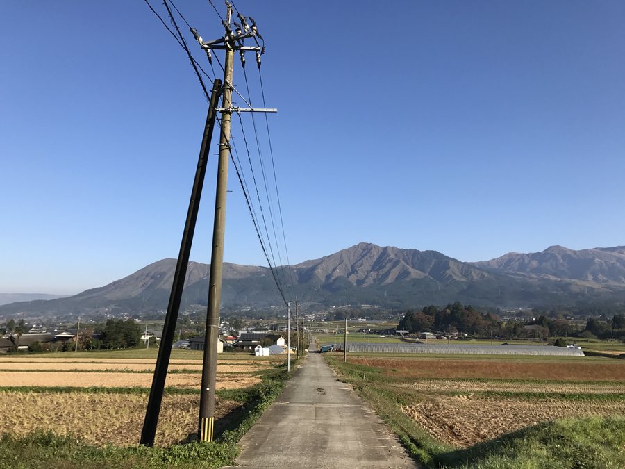 南阿蘇の田園から望む阿蘇五岳。手前に畑と農道が広がる