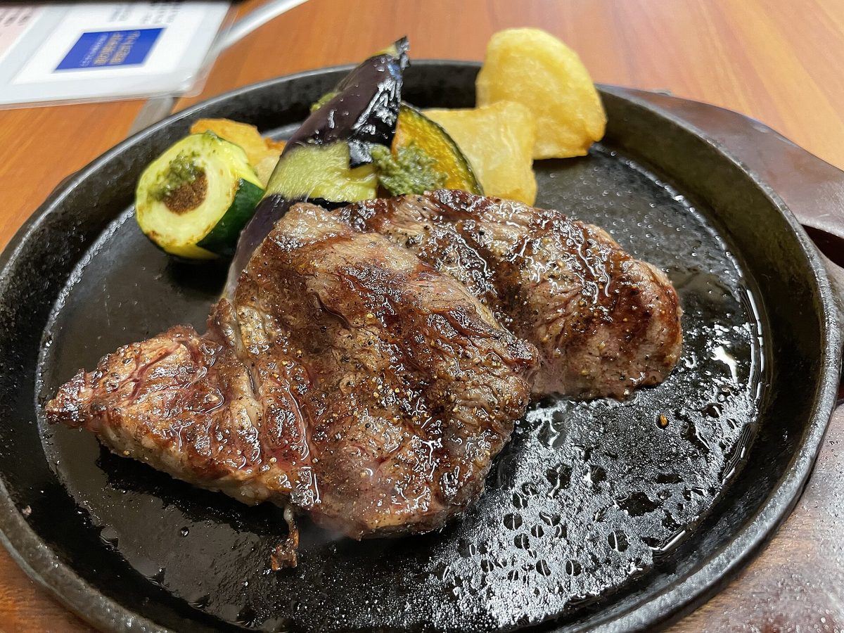 熱々の鉄板に盛られた米沢牛ステーキと彩り野菜