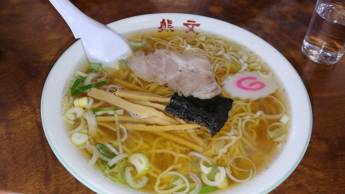 澄んだ醤油スープと細ちぢれ麺の米沢ラーメン、チャーシューとなるとをのせた一杯