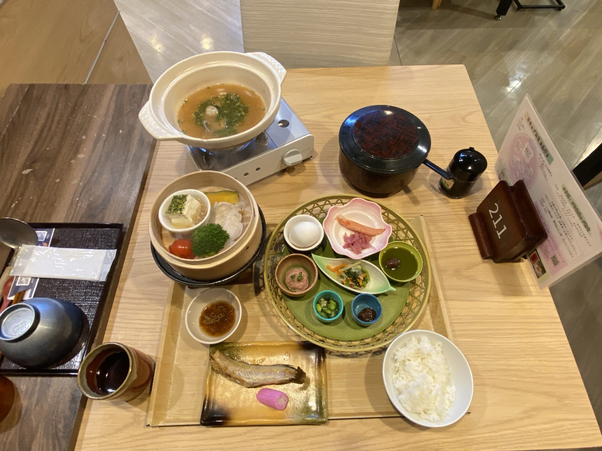 朝食の全体を上から（籠盛りの小鉢・せいろ・おひつ）